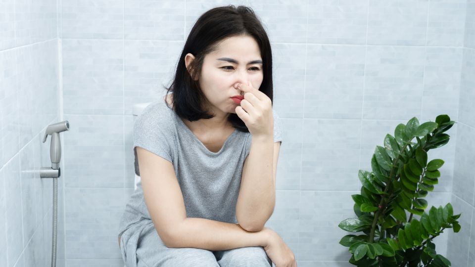 Pregnant woman looking concerned about changes in urine odor.