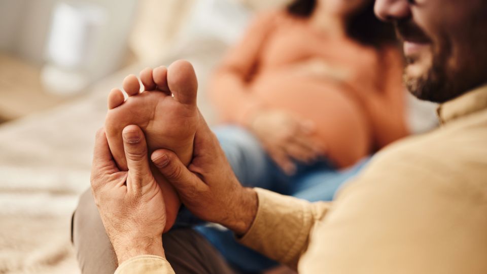 Pregnant woman receiving a foot massage in a calm setting