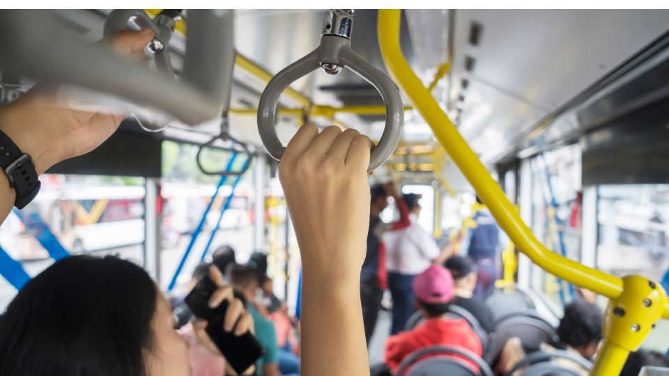 A pregnant woman on a crowd bus