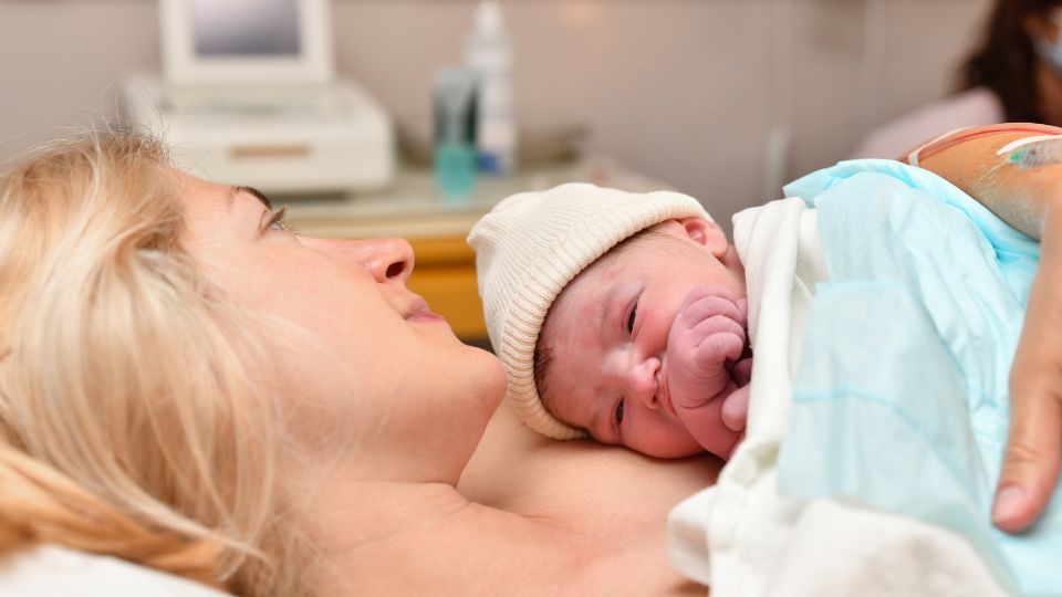 A parent gently applying a baby-friendly moisturizer to their newborn’s soft skin.