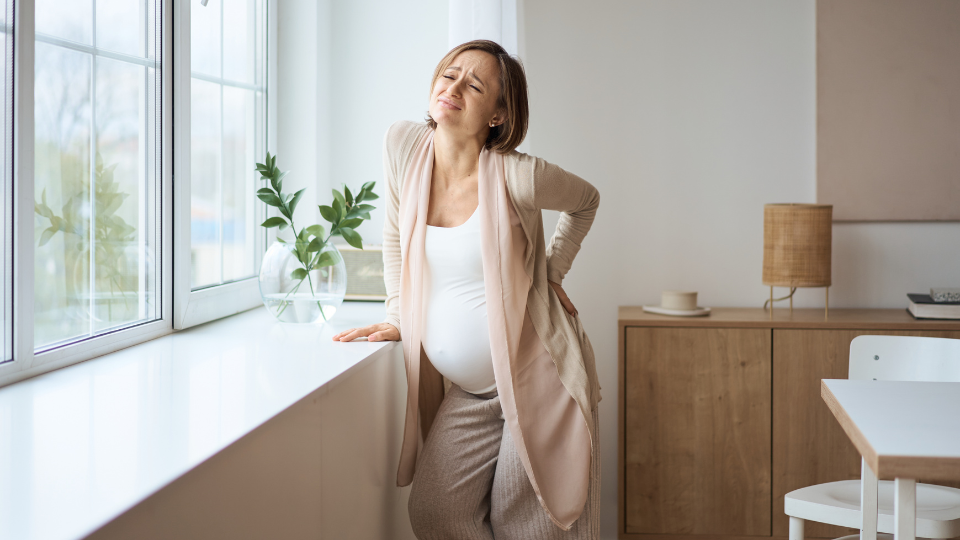 Pregnant woman using a heating pad on her back