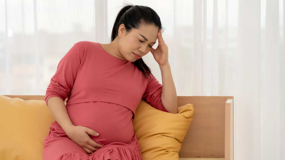 Pregnant woman applying cream to her belly to prevent stretch marks