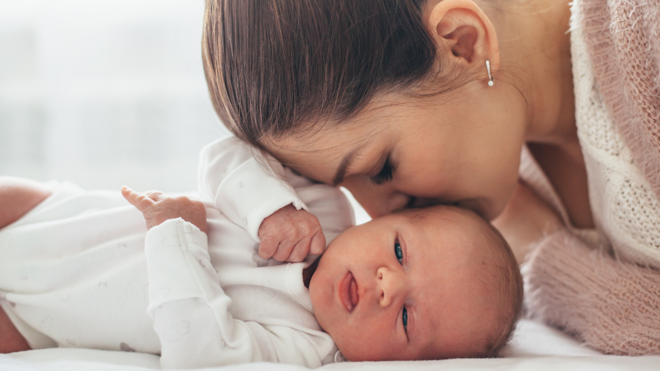 Parent gently caring for newborn baby hair