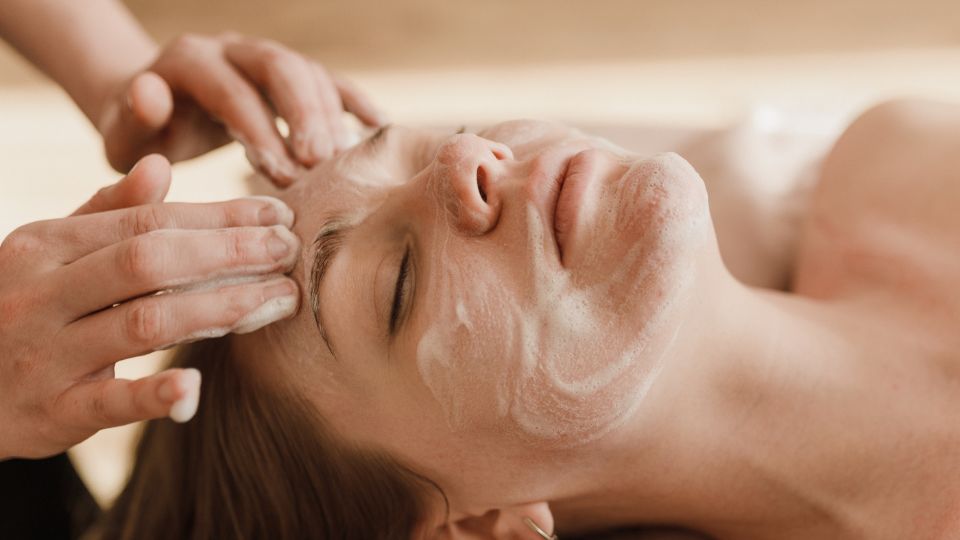 A pregnant woman receiving a facial in a spa setting.