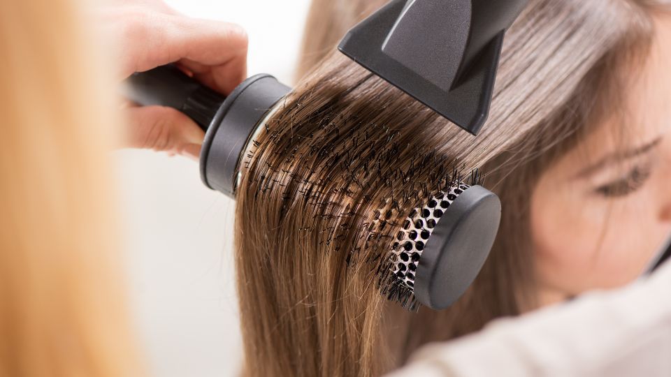 Pregnant woman at a hair salon considering hair rebonding.